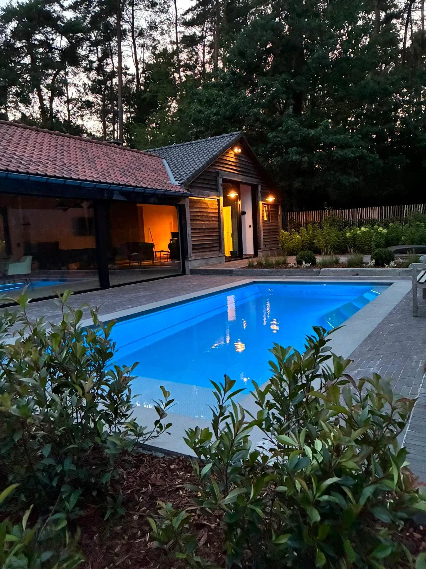 WaterRows Single 78 keramisch zwembad in Champagne Pearl met blauwe LED-verlichting bij een landelijke woning